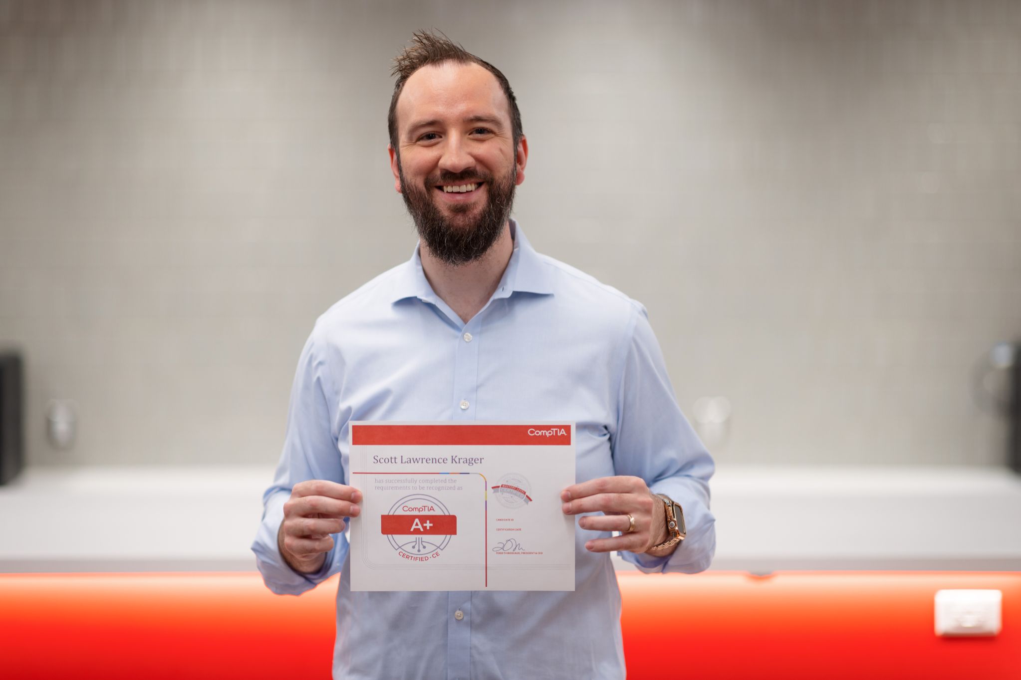 Scott Krager holding his CompTIA+ Certificate