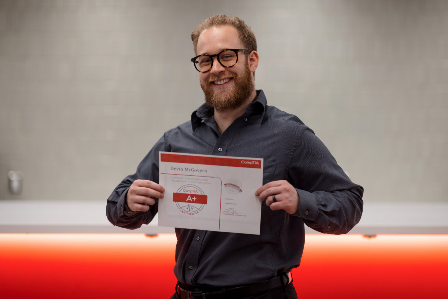 Devin McGovern holding his CompTIA+ Certificate
